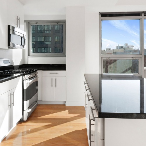 Kitchen with a stove ample cabinet space and large windows
